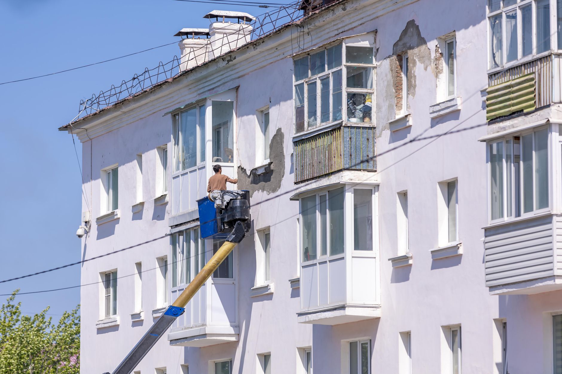 Fassadenarbeiten an einem Gebäude mit Hubarbeitsbühne